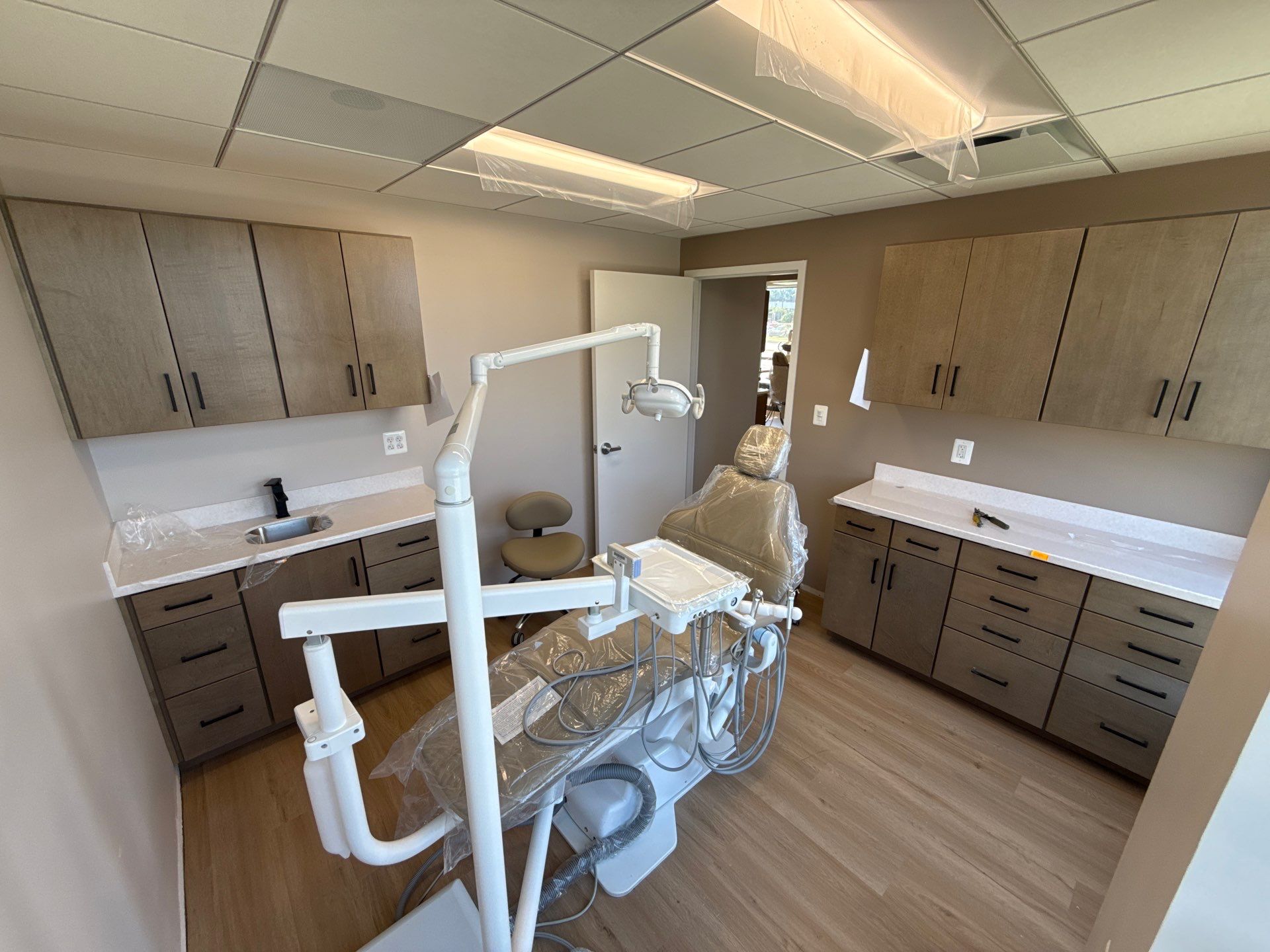 Completed dental operatory with maple casework, quartz countertops, and a protected treatment chair