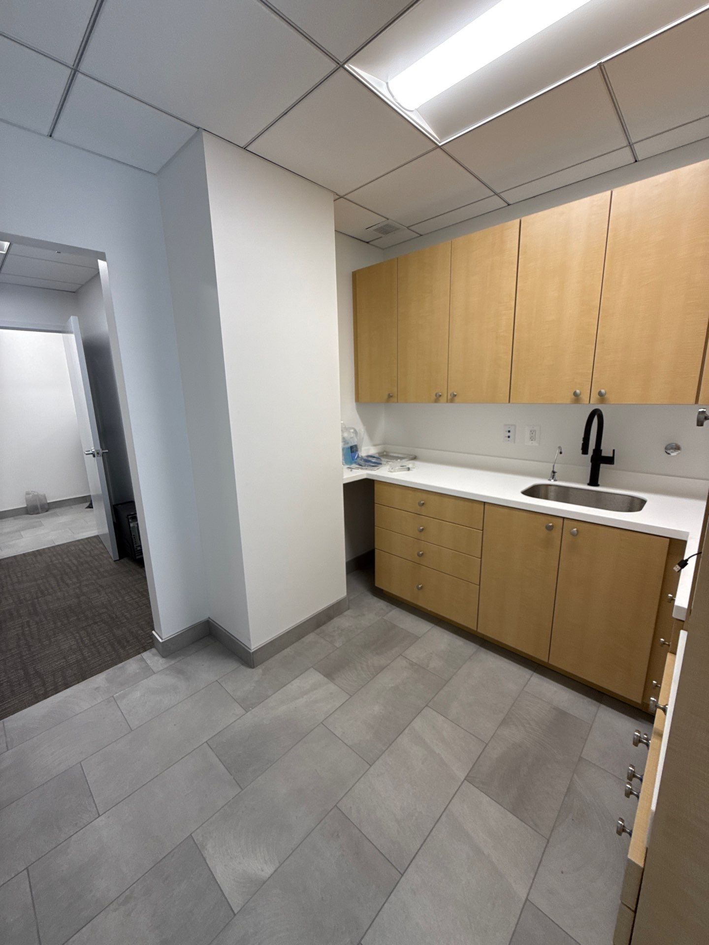 Completed clinical support room with warm wood millwork and quartz countertops